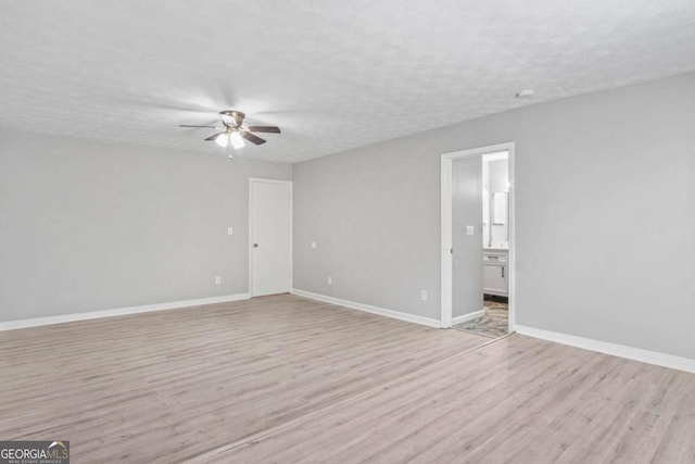 spare room with ceiling fan, light hardwood / wood-style floors, and a textured ceiling