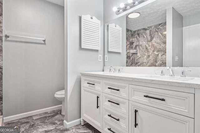 bathroom featuring a textured ceiling, vanity, and toilet