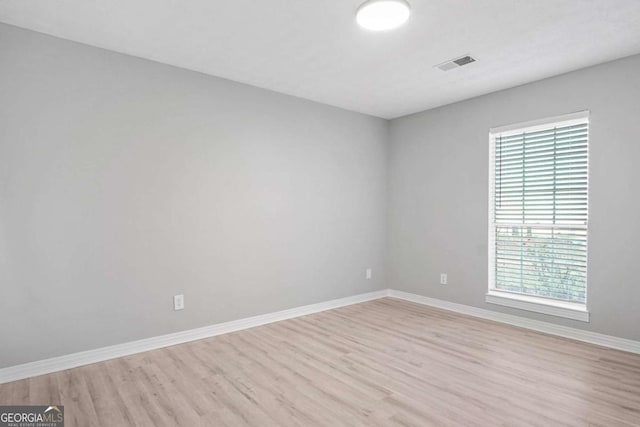 empty room with a healthy amount of sunlight and light hardwood / wood-style flooring