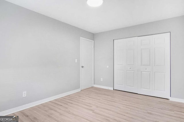 unfurnished bedroom featuring light hardwood / wood-style floors and a closet