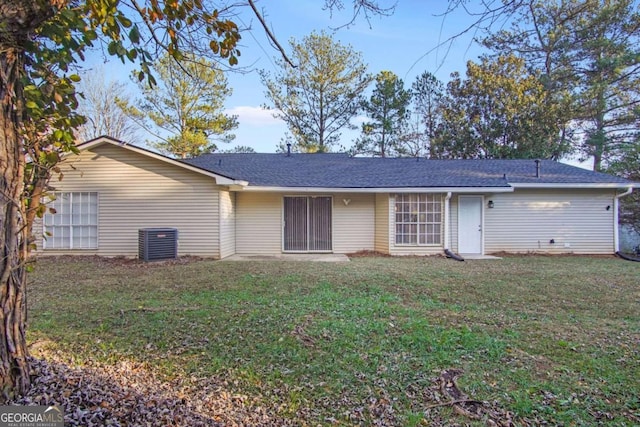 back of property with a lawn and central AC