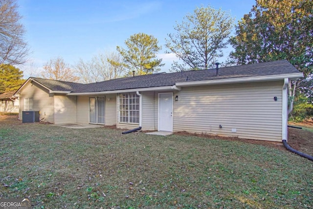 rear view of house with a lawn and central air condition unit