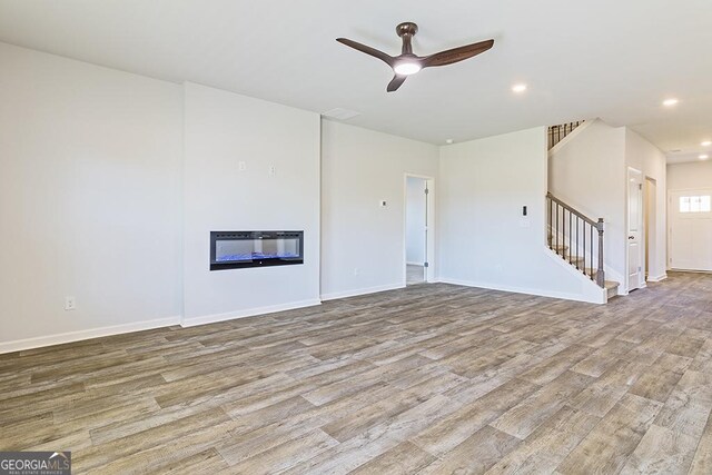 unfurnished living room with ceiling fan and light hardwood / wood-style floors