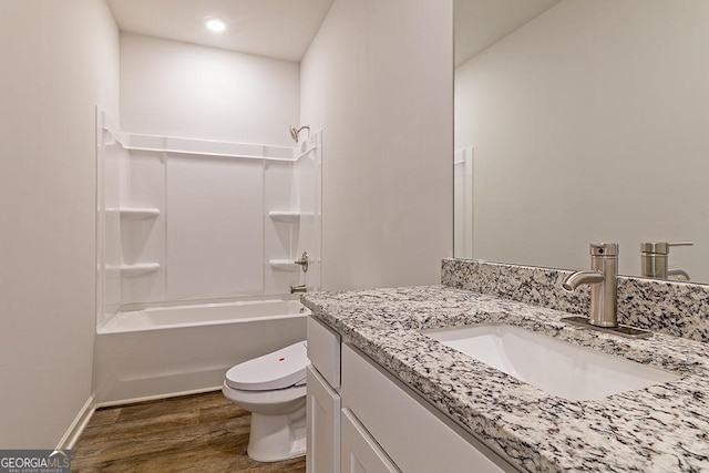 full bathroom with hardwood / wood-style flooring, vanity, toilet, and tub / shower combination