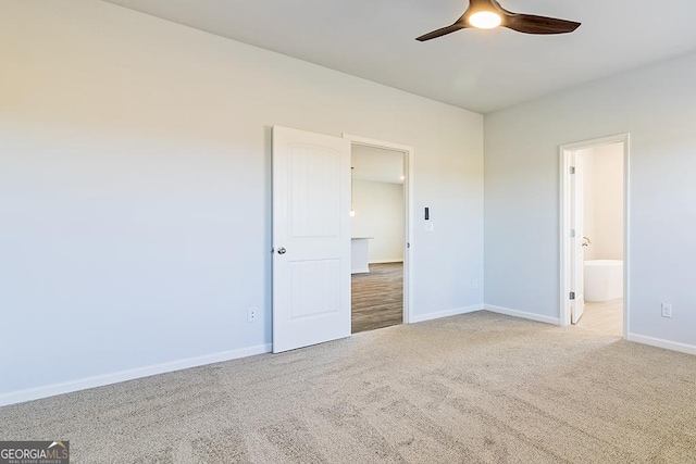 unfurnished bedroom with ceiling fan, light colored carpet, and connected bathroom