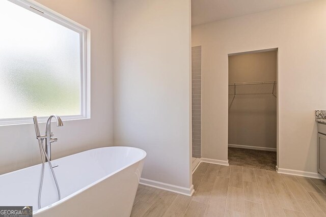 bathroom with plus walk in shower, hardwood / wood-style floors, and vanity