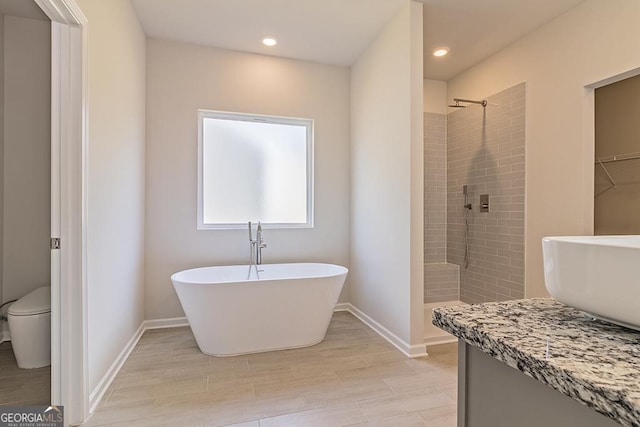 full bathroom featuring hardwood / wood-style floors, vanity, separate shower and tub, and toilet