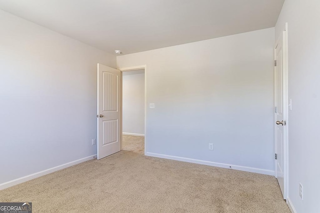 unfurnished room featuring light colored carpet