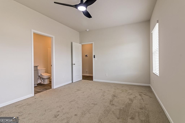 unfurnished bedroom featuring carpet floors, ensuite bathroom, and ceiling fan