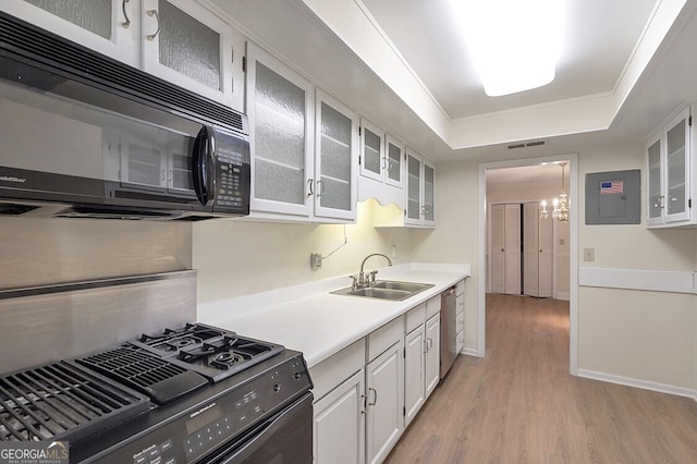 6851 Roswell Rd Unit D14, Atlanta, GA 30328 - kitchen featuring black appliances, electric panel, light wood-style flooring, light countertops, and white cabinetry