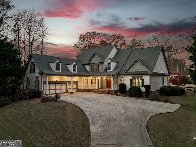 view of front of house with a garage, a porch, and a yard