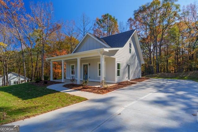 view of front of home with covered porch and a front lawn