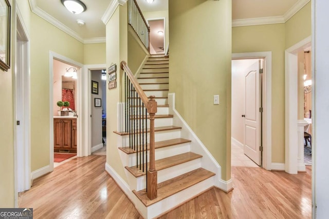 stairway with hardwood / wood-style flooring and crown molding