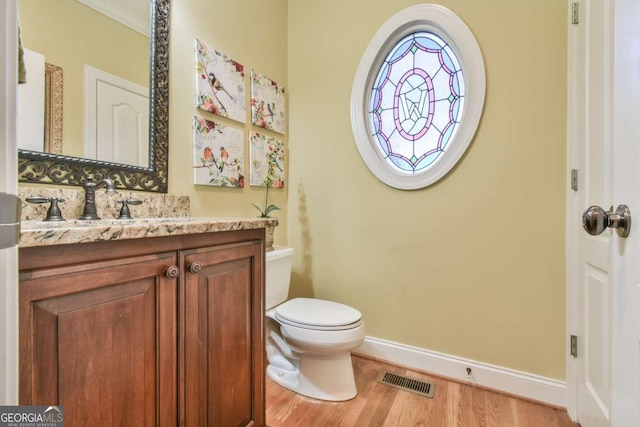 bathroom with hardwood / wood-style floors, vanity, toilet, and crown molding