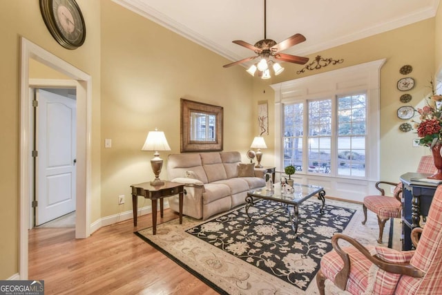 living room featuring light wood-type flooring, ceiling fan, and crown molding