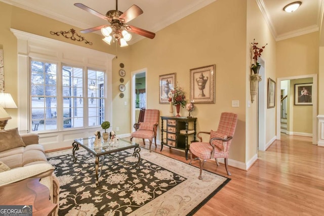 living room featuring plenty of natural light, ceiling fan, ornamental molding, and light hardwood / wood-style flooring