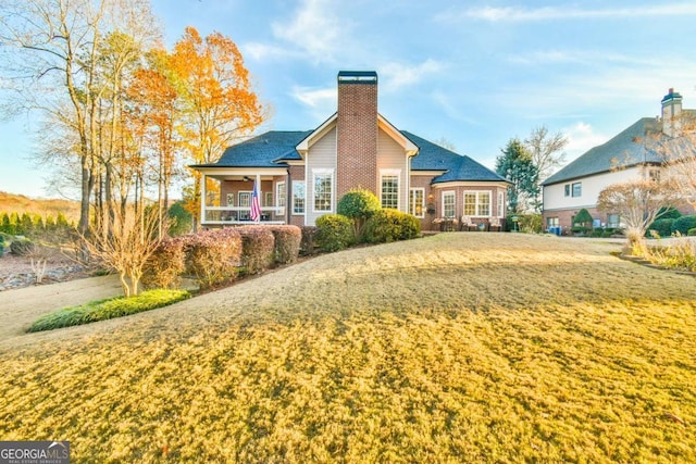 rear view of property featuring a yard