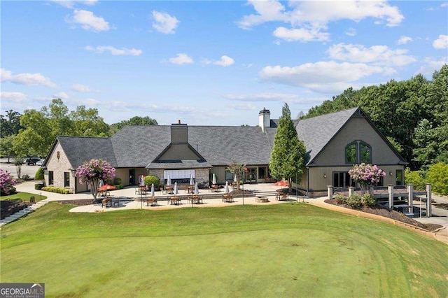 rear view of house featuring a patio area and a yard