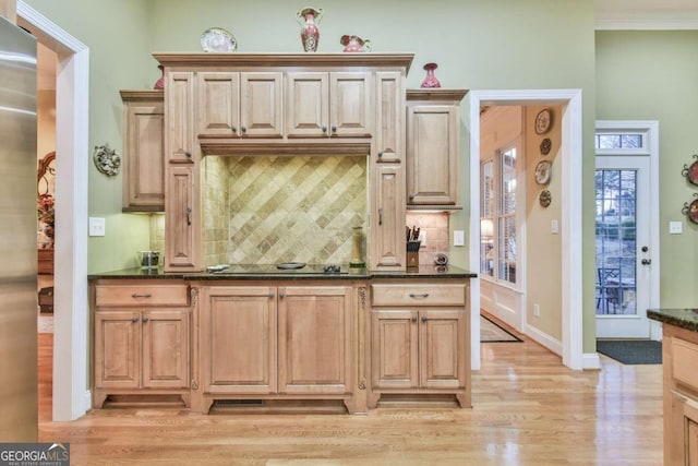 kitchen featuring light hardwood / wood-style floors, crown molding, light brown cabinets, and tasteful backsplash