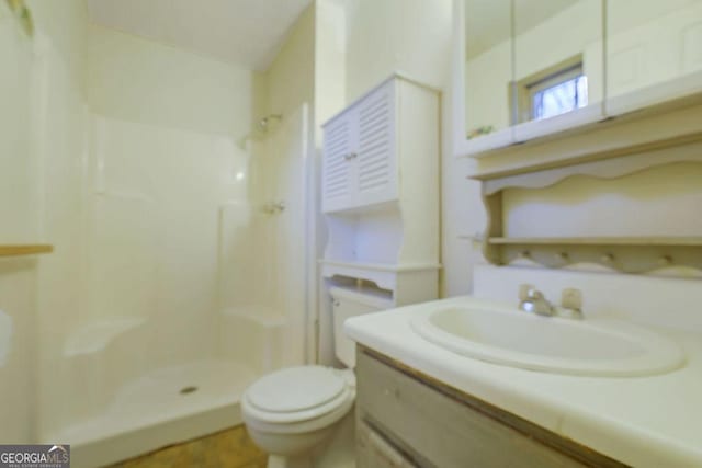 bathroom featuring vanity, toilet, and walk in shower