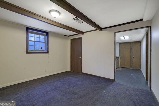 unfurnished room with beam ceiling and dark carpet