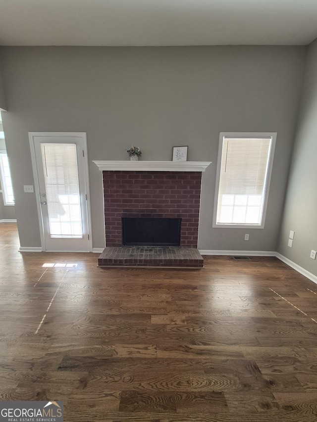 unfurnished living room featuring dark hardwood / wood-style flooring and a fireplace