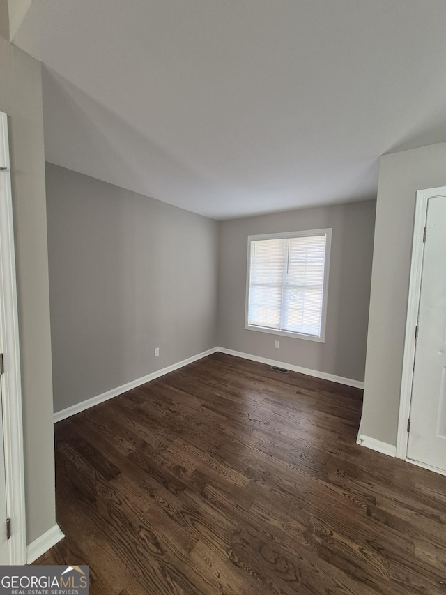 empty room featuring dark hardwood / wood-style flooring