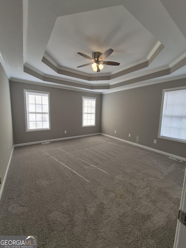 carpeted spare room featuring ceiling fan, a raised ceiling, and crown molding