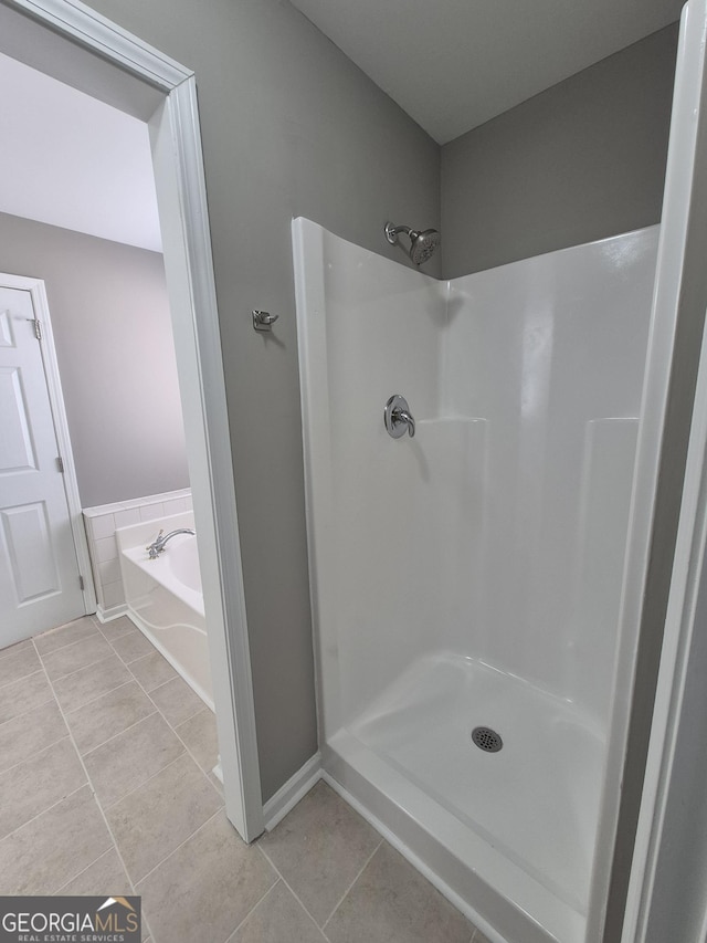 bathroom featuring tile patterned flooring and shower with separate bathtub