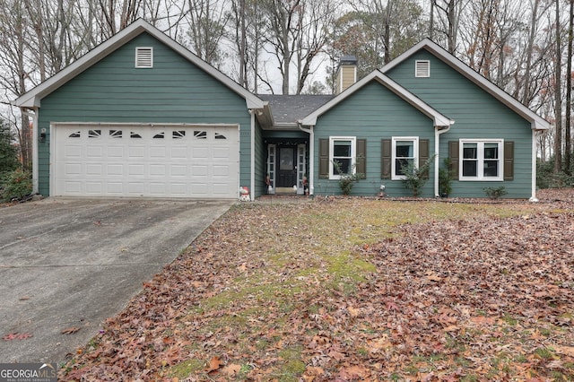 view of front of house with concrete driveway, a chimney, and an attached garage