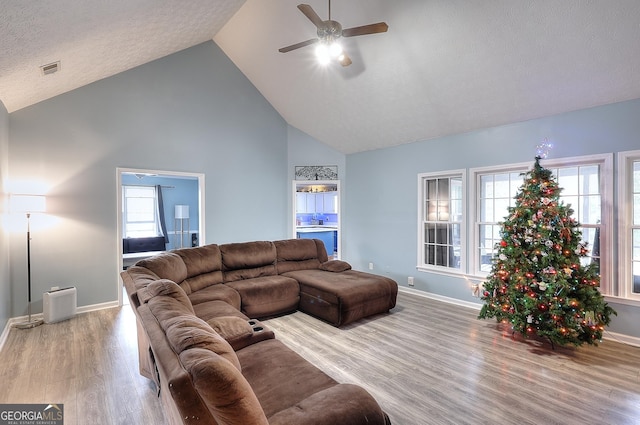 living room featuring ceiling fan, plenty of natural light, high vaulted ceiling, and light hardwood / wood-style floors