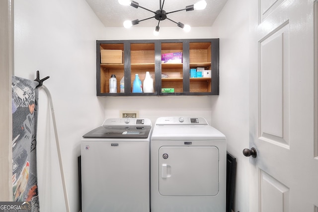 clothes washing area with a textured ceiling, laundry area, and washer and clothes dryer