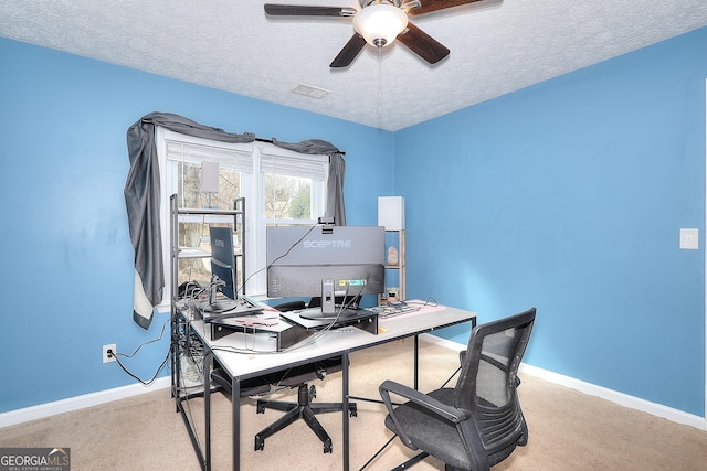 carpeted office with a textured ceiling and ceiling fan