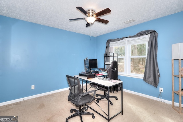 carpeted home office featuring ceiling fan and a textured ceiling