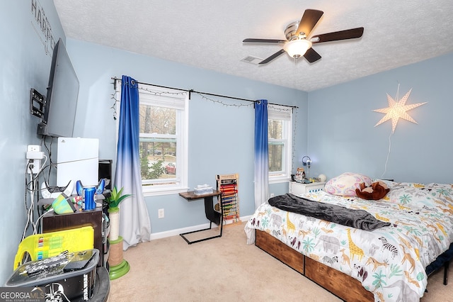 carpeted bedroom featuring ceiling fan and a textured ceiling