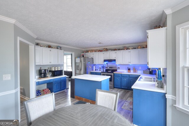 kitchen featuring sink, a center island, ornamental molding, and appliances with stainless steel finishes