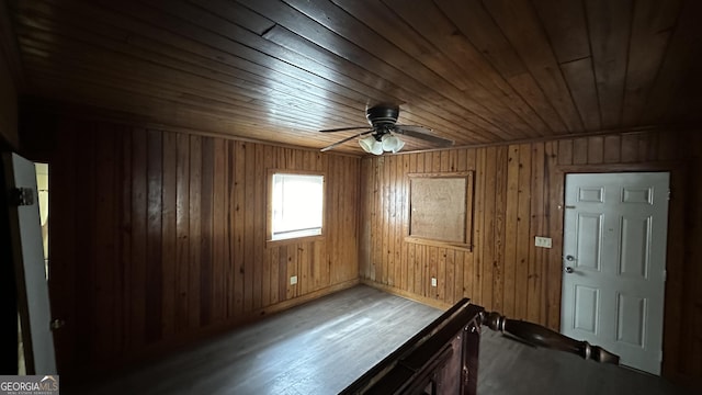 empty room featuring ceiling fan, wood walls, and wood ceiling