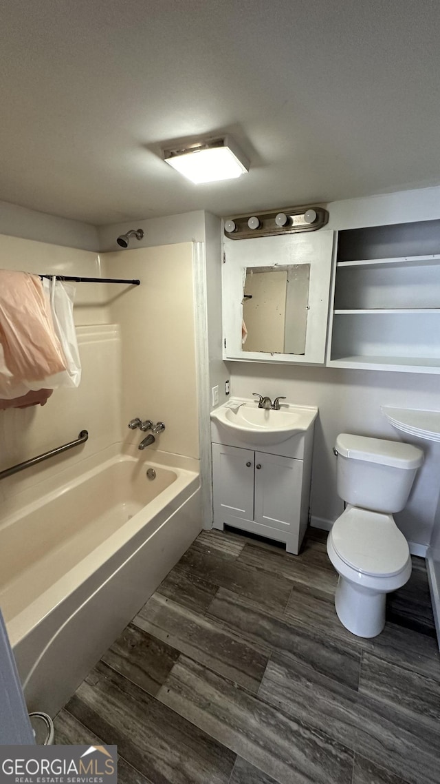 full bathroom featuring toilet, wood-type flooring, vanity, and bathing tub / shower combination