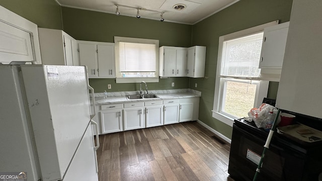 kitchen featuring light hardwood / wood-style flooring, white fridge, white cabinetry, and sink