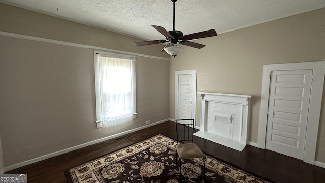 living room with a textured ceiling, dark hardwood / wood-style floors, and ceiling fan