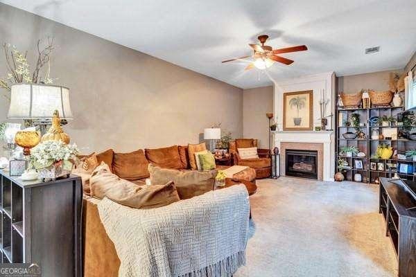 carpeted living room with ceiling fan and a healthy amount of sunlight