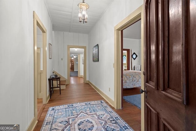 hallway featuring light hardwood / wood-style floors and an inviting chandelier