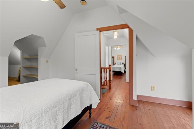 bedroom with ceiling fan, wood-type flooring, and lofted ceiling