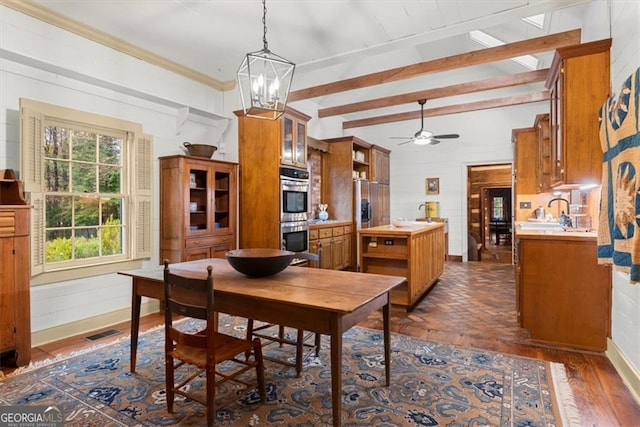 dining space with ceiling fan with notable chandelier, crown molding, dark wood-type flooring, sink, and beamed ceiling