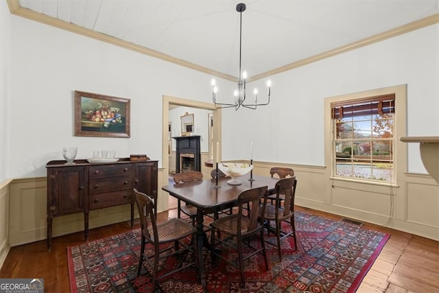 dining room featuring a chandelier, ornamental molding, and hardwood / wood-style flooring