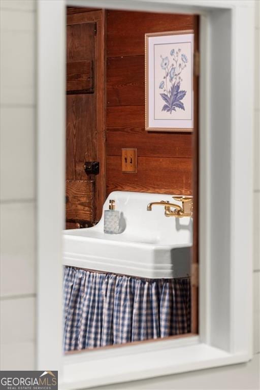 bathroom featuring wooden walls