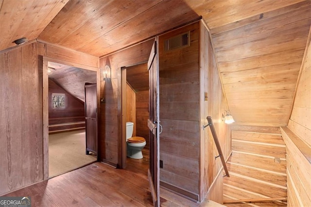 interior space with wood walls, wood-type flooring, wood ceiling, and vaulted ceiling