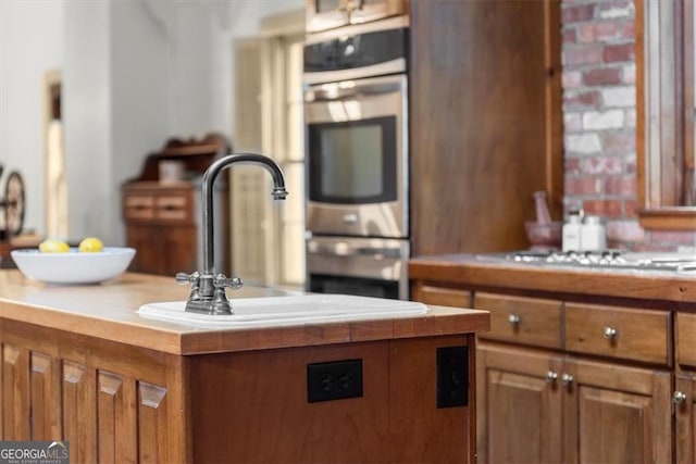 kitchen featuring cooktop, a center island, and sink