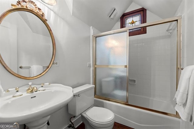 full bathroom featuring toilet, lofted ceiling, sink, and bath / shower combo with glass door