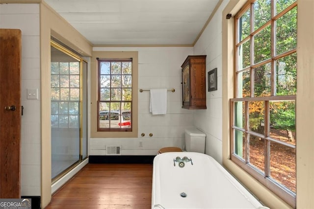 bathroom featuring wood-type flooring, a tub, and ornamental molding